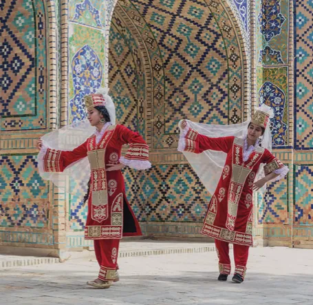 Deux danseuses en costume traditionnel devant une façade décorée