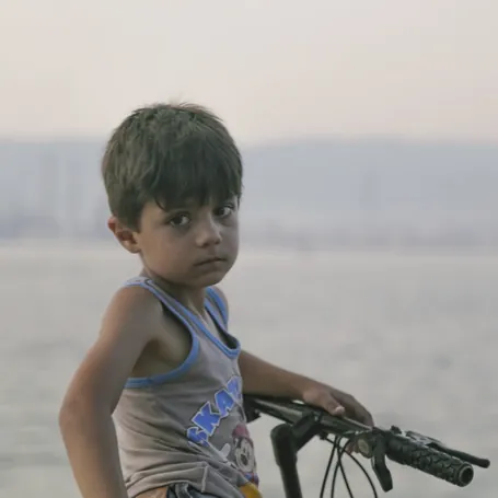 Un jeune garçon sur un vélo au bord de l’eau